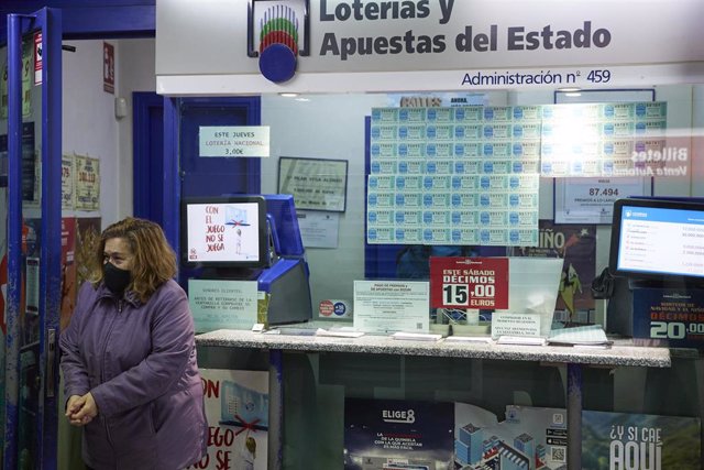Una empleada en la administración situada en la zona del AVE de la Estación de Atocha que ha vendido parte del número 44469 correspondiente al segundo premio del Sorteo Extraordinario de la Lotería de Navidad, a 6 de enero de 2022, en Madrid.