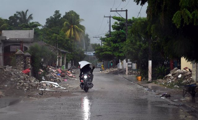 Una persona conduciendo una moto en una calle de Haití.