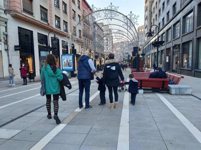 Una familia con niños pasea por las calles de Oviedo durante la Navidad de 2021.