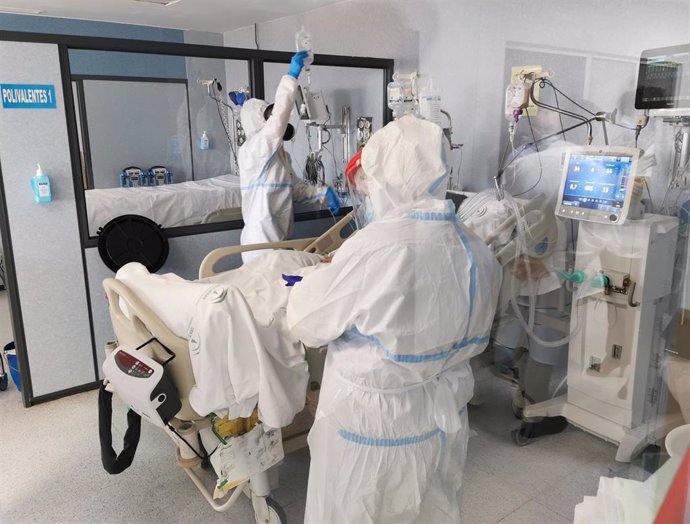 Archivo - Profesionales sanitarios protegidos ante el covid-19 atienden a un paciente en el Hospital Torrecárdenas.