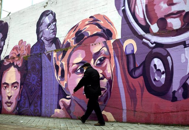 Archivo - Un hombre pasa por el mural feminista en el polideportivo municipal de la Concepción en el distrito de Ciudad Lineal