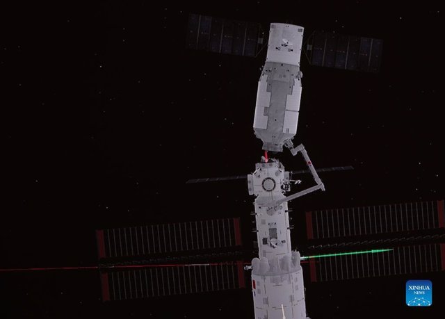 Imagen del brazo robótico moviendo al carguero en maniobra de ensamblaje con la estación espacial china