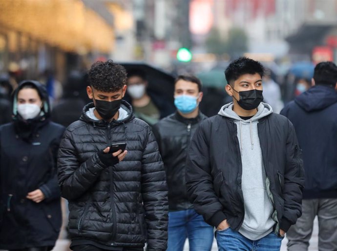 Varias personas con mascarilla.