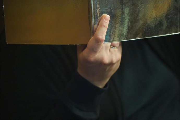 El condenado a cadena perpetua en un caso de canibalismo se tapa la cara en el tribunal de Berlín, la capital de Alemania, donde se le juzga. 