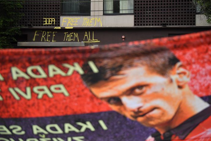 Supporters unfurl a banner outside the Park hotel quarantine facility where it is believed Serbian tennis player Novak Djokovic is being detained in Melbourne, Friday, January 7, 2022. World No.1 tennis star Novak Djokovic is fighting his visa cancellat