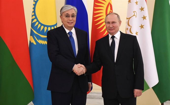 HANDOUT - 28 December 2021, Russia, Saint Petersburg: Kassym-Jomart Tokayev (L), President of Kazakhstan, shakes hands with Russian President Vladimir Putin prior to the start of a meeting between the leaders of the Commonwealth of Independent States (C