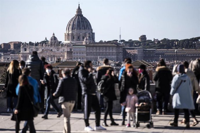 Personas con mascarilla con el Vaticano de Roma al fondo