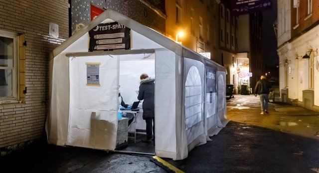 07 January 2022, Schleswig-Holstein, Luebeck: A person stands inside the Test-Spaeti which is located in Luebeck's old town. Pub-goers can get tested for the Coronavirus here three days a week until midnight. Photo: Markus Scholz/dpa