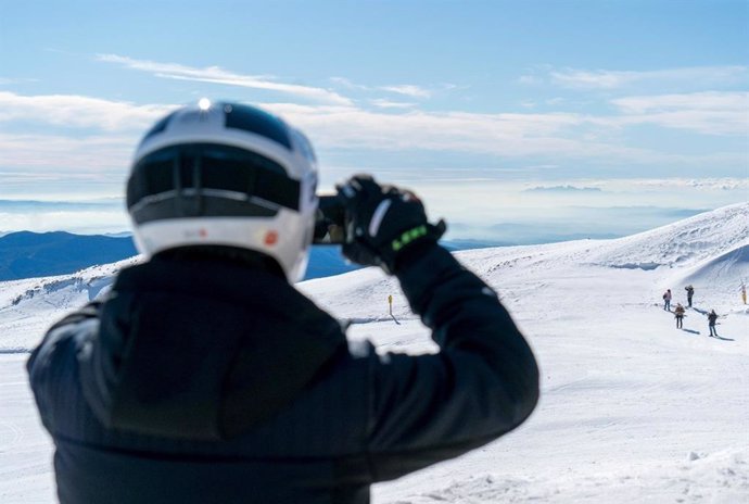 Un esquiador toma una foto en una montaña nevada