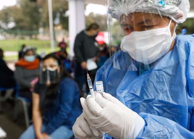 Archivo - Un trabajador sanitario prepara una vacuna contra el coronavirus en Perú