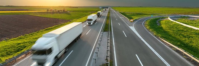 Archivo - Varios camiones circulan por una carretera