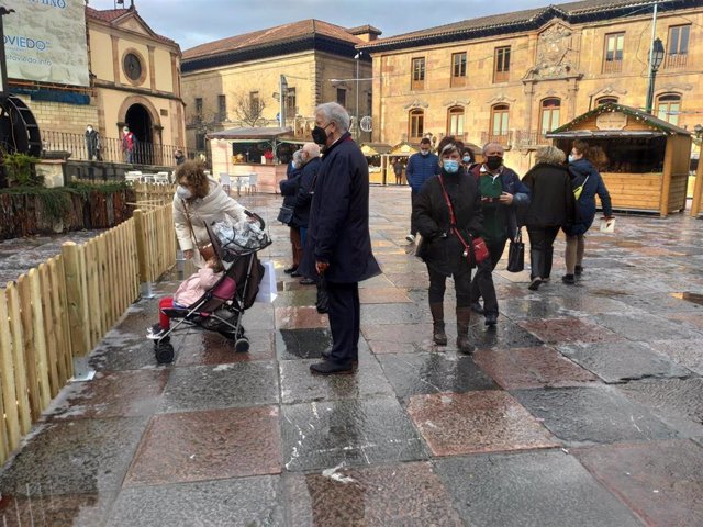 Archivo - Personas paseando por la Plaza de la Catedral de Oviedo durante un día de otoño, con el Belén y las casetas del mercadillo navideño ya instaladas.