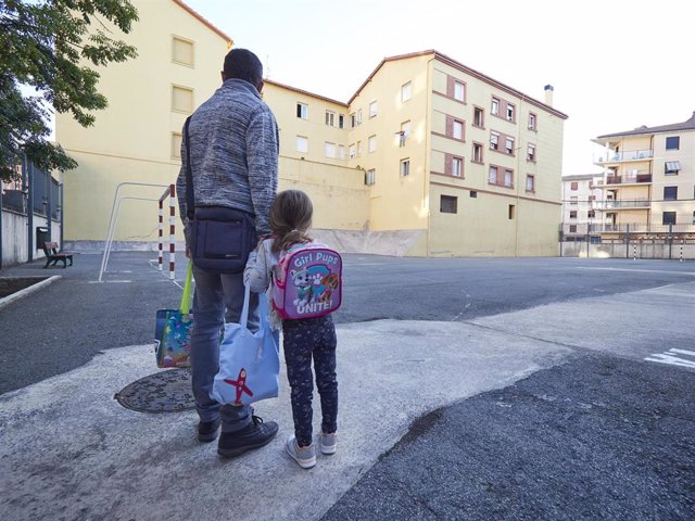 Archivo - Un padre y su hija frente a las puertas de un centro escolar navarro (archivo)