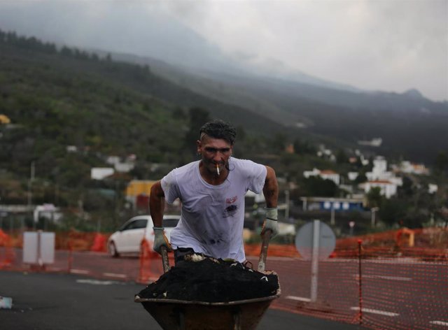 Un trabajador transporta cenizas del volcán de Cumbre Vieja desde Tajuya