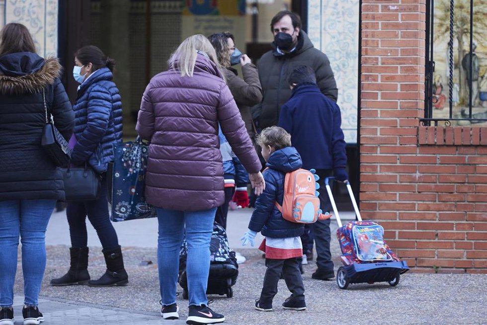 Una madre deja a su hijo en la puerta del colegio tras las vacaciones de Navidad con la aplicación de las nuevas restricciones dependiente de cada comunidad autónoma, a 10 de enero de 2022 en Sevilla (Andalucía, España)