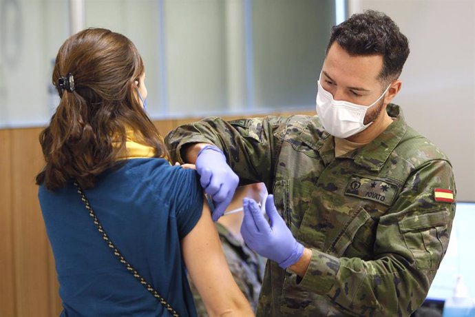 Un militar de las Fuerzas Armadas vacuna a una mujer contra la COVID en Palma.