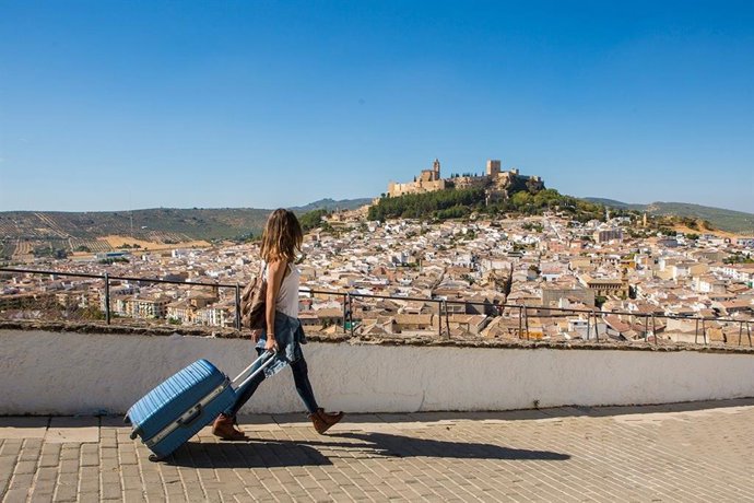 Archivo - Una turista pasea por Alcalá la Real, con la Fortaleza de la Mota al fondo.