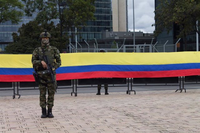 Un militar delante de una bandera de Colombia.
