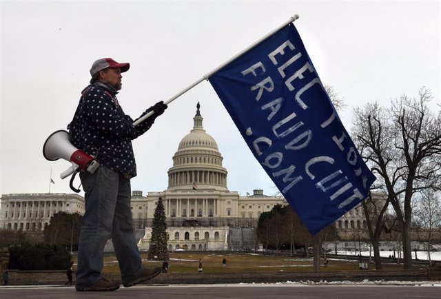 Un manifestante con una bandera en el aniversario del asalto al Capitolio