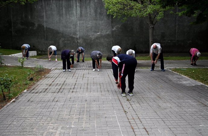 Archivo - Un grupo de ancianos realiza ejercicio en el jardín de un centro de día (archivo)