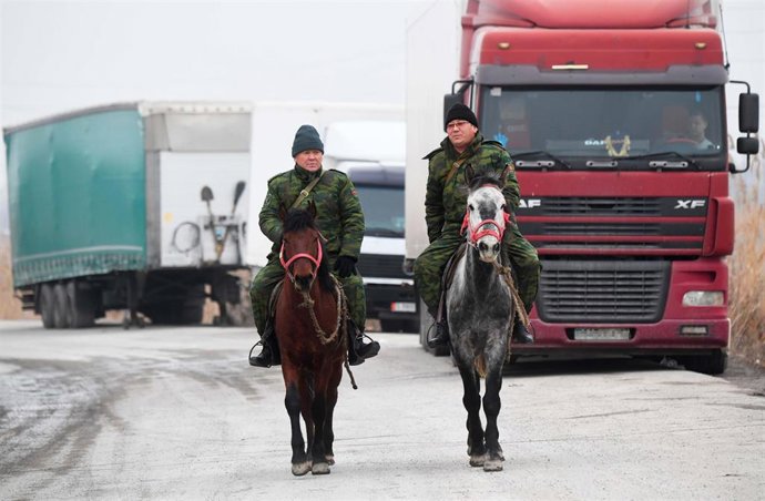 Dos personas son fotografiadas en el paso fronterizo de Ak-Tilek, en la frontera entre Kirguistán y Kazajstán.