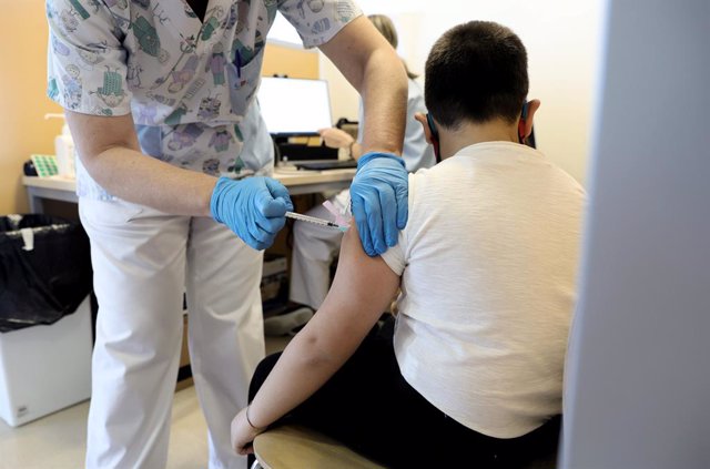 Un trabajador sanitario inyecta la vacuna contra el Covid-19 a un menor, en el Hospital Infanta Sofía, a 30 de diciembre de 2021, en San Sebastián de los Reyes, Madrid, (España). La Comunidad de Madrid permite desde hoy inocular la vacuna contra el COVID-