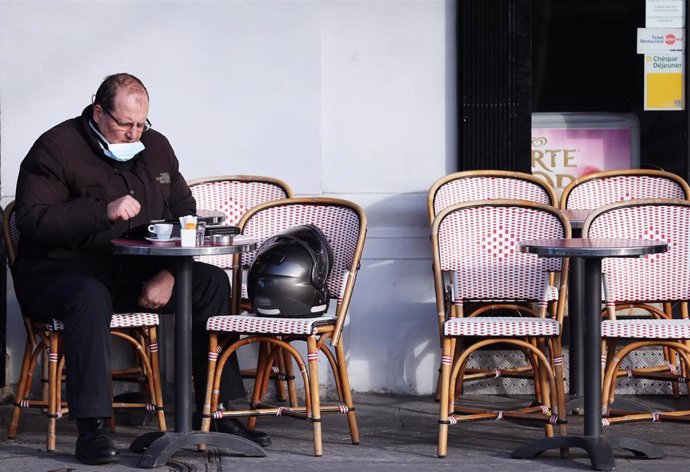 Un cliente con mascarilla en una cafetería de París