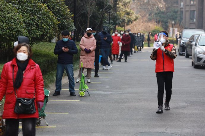 Un voluntario recuerda la necesidad de guardar distancia en Xian