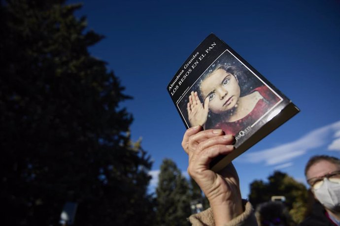 Archivo - Una persona con un libro en la mano en homenaje a Almudena Grandes 