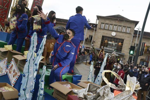 Un grupo de personas que participa en la cabalgata de Reyes reparte caramelos, a 5 de enero de 2022, en Ourense, Galicia (España). 