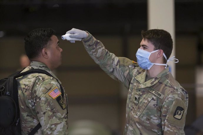 Archivo - Un soldado toma la temperatura a compañero de filas en un cuartel militar en Seattle.