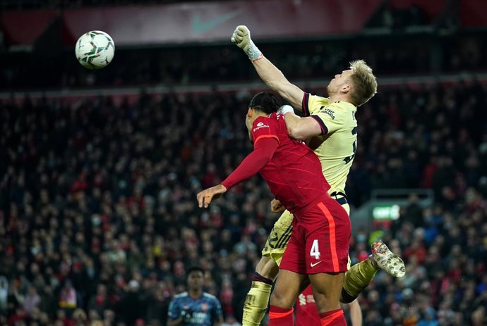 13 January 2022, United Kingdom, Liverpool: Arsenal goalkeeper Aaron Ramsdale (R) and Liverpool's Virgil van Dijk battle for the ball during the English Carabao Cup semifinal first leg soccer match between Liverpool and Arsenal at Anfield. Photo: Peter 