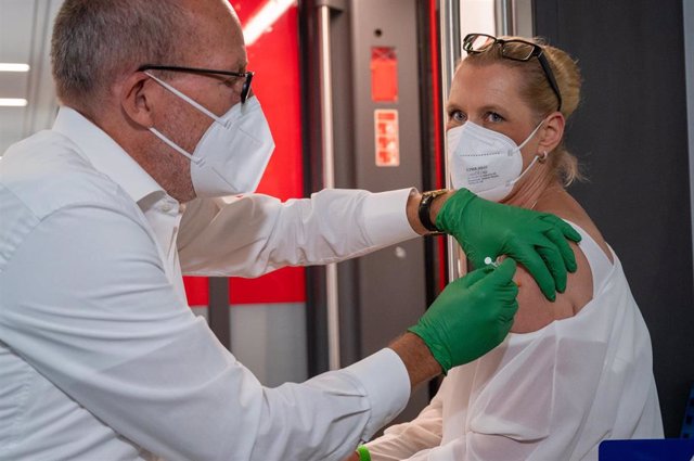 Archivo - FILED - 30 August 2021, Berlin: Christian Gravert, chief medical officer of Deutsche Bahn, vaccinates a woman in a special train of the S-Bahn, in which vaccinations with the vaccine of the manufacturer Johnson & Johnson are offered.