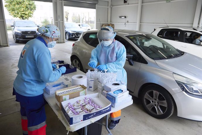 Dos enfermeras preparan el test en una mesa durante la realización de PCR en el autocovid instalado en el Hospital Militar, a 28 de diciembre de 2021 en Sevilla (Andalucía, España)