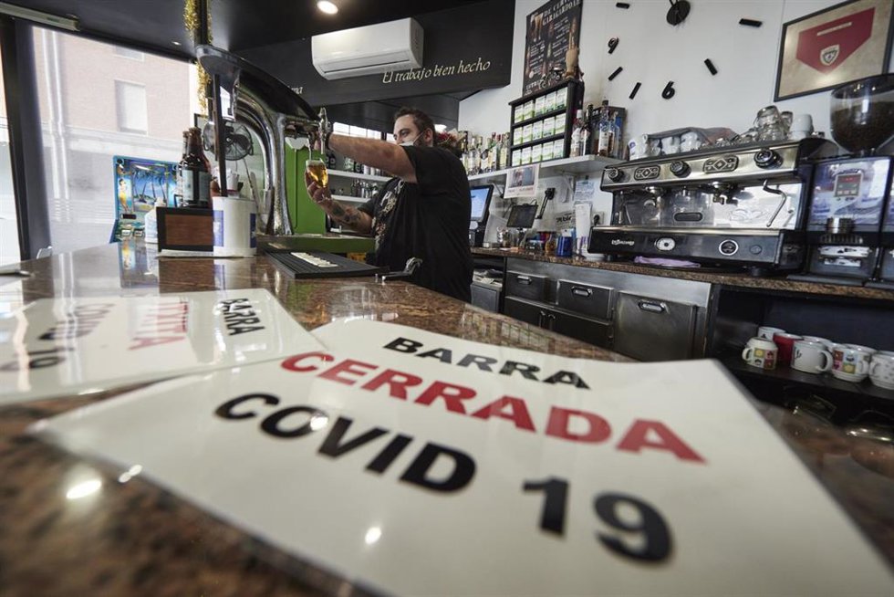 Un camarero trabajando en un bar afectado por restricciones ante los contagios de Covid