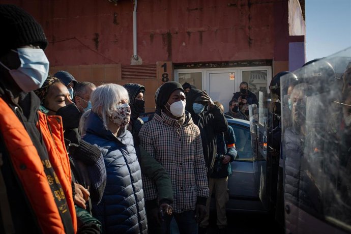 Agentes de policía intentan desalojar una nave industrial okupada que se encuentra en desuso en la calle Progrés de Badalona, a 13 de enero de 2022, en Badalona, Barcelona, Catalunya, (España). La nave, ocupada por más de un centenar de personas de orig