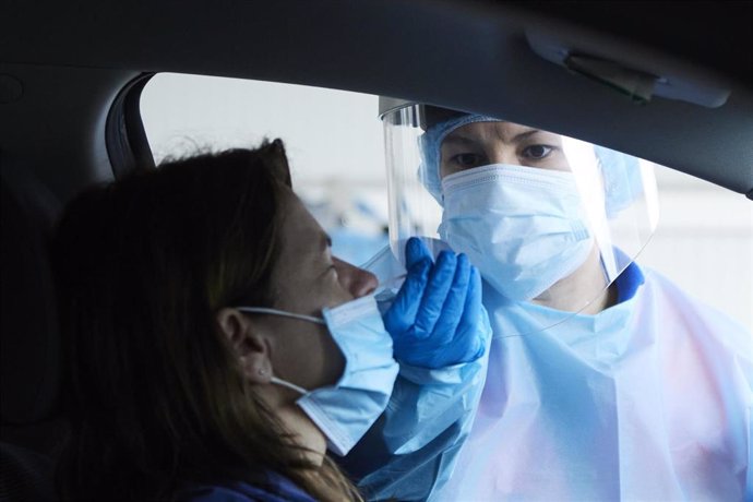 Una sanitaria le realiza la prueba PCR a una mujer en su coche. 