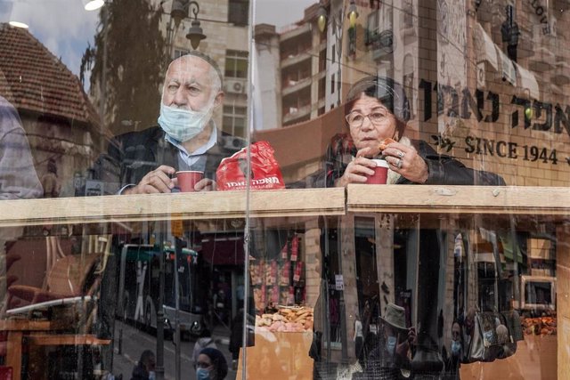 Archivo - Dos personas toman un café en Jerusalén durante la pandemia.