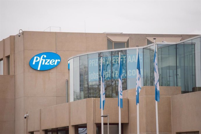 Archivo - 23 December 2020, Belgium, Puurs: The company logo hangs on Pfizer's production facility, where the coronavirus (Covid-19) vaccine of Pfizer-BioNTech is produced.