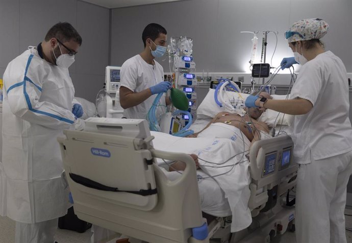 Varios sanitarios alrededor de un paciente ingresado en la UCI del Hospital Enfermera Isabel Zendal, a 13 de enero de 2022, en Madrid (España).