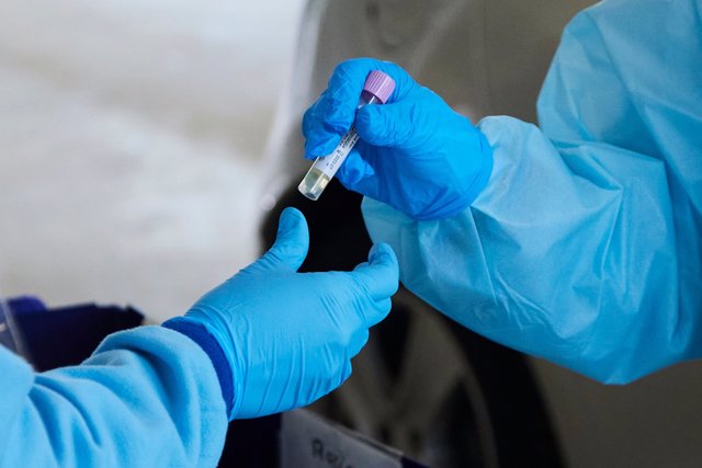 Una enfermera da una muestra de PCR para su análisis durante la realización de PCR en el autocovid instalado en el Hospital Militar, a 28 de diciembre de 2021 en Sevilla