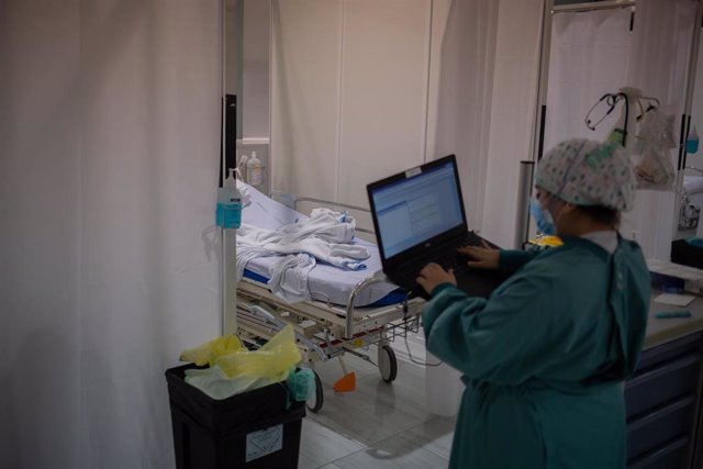 Archivo - Una sanitaria toma datos en su ordenador en una habitación de una Unidad de Cuidados Intensivos  (UCI), foto de recurso