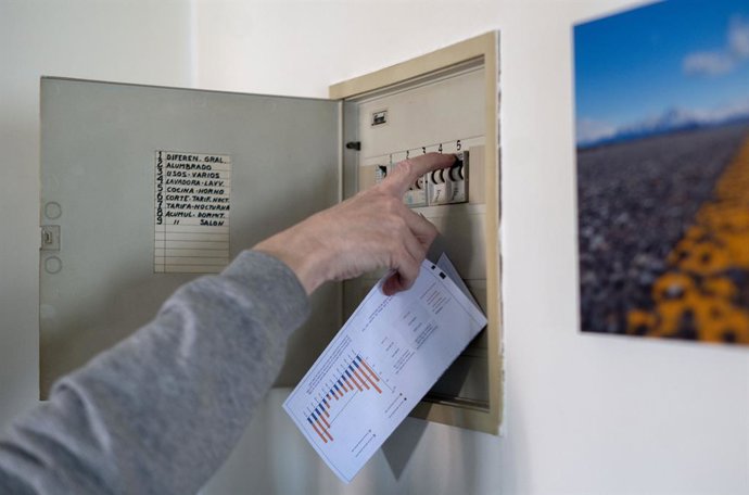 Un home puja els ploms de la llum amb una factura de llum a la m, a 3 de gener de 2022, a Madrid