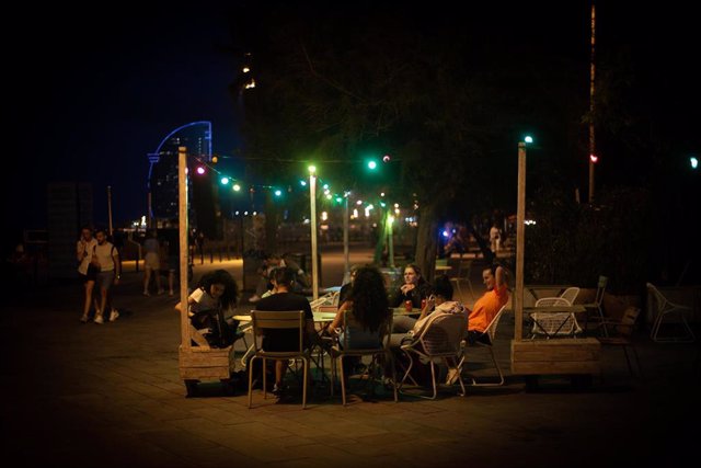 Archivo - Varias personas en la terraza de un bar, frente a la playa de la Barceloneta