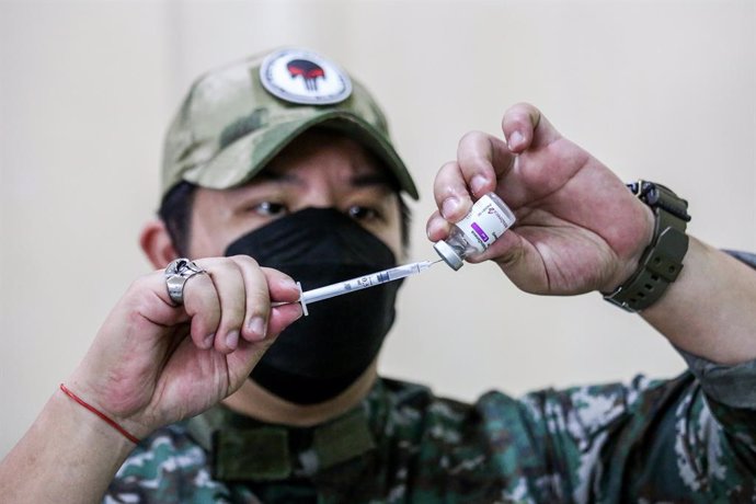 Archivo - 29 November 2021, Philippines, Quezon City: A police officer in the Medical Reserve Force prepares an anti-coronavirus vaccine booster shot amid a nationwide three-day vaccination drive to give Covid-19 shots to up to 9 million Filipinos. Phot
