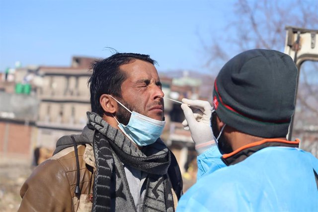 12 January 2022, India, Poonch: A health worker collects a swab sample from a man for COVID-19 testing. Photo: Nazim Ali Khan/ZUMA Press Wire Service/dpa