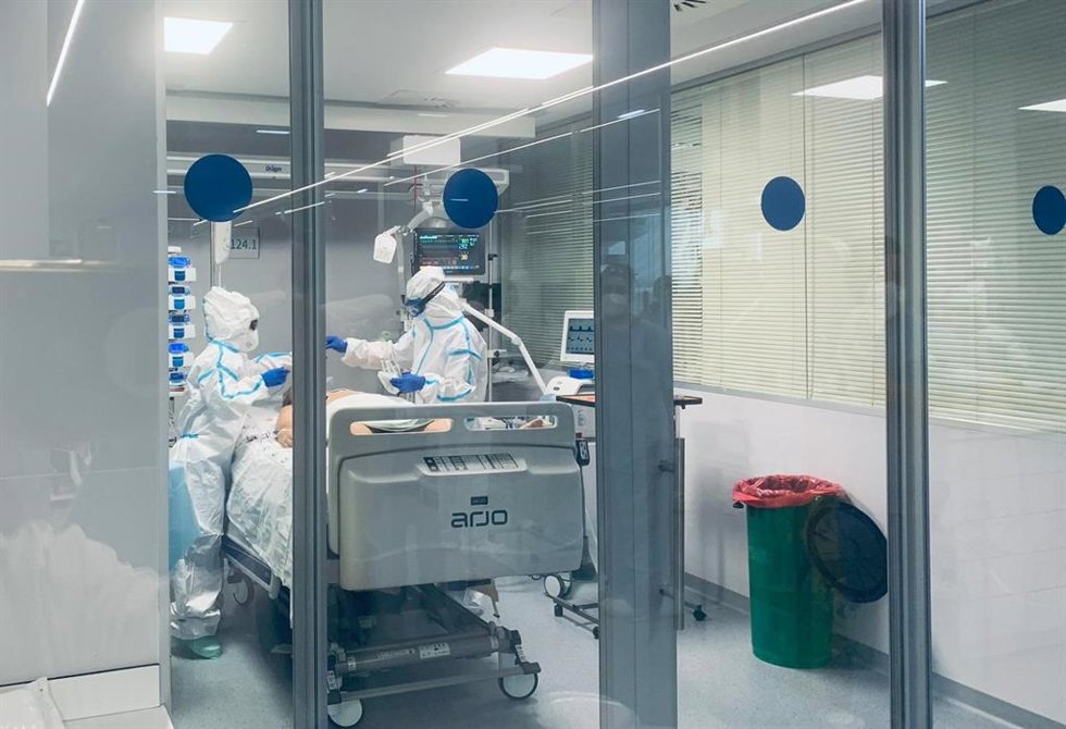 Dos sanitarios atienden a un paciente COVID en el Hospital Virgen de la Victoria de Málaga