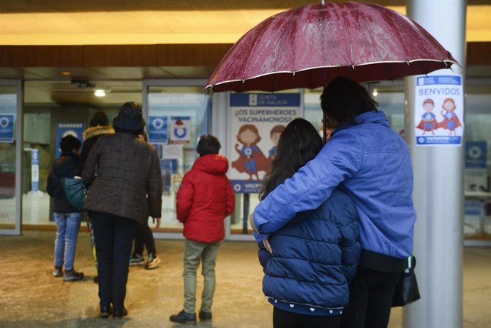 Varios niños acompañados de sus padres, a su llegada al recinto ferial Expourense para ser vacunados, el día en el que han reanudado el proceso de vacunación infantil, a 4 de enero de 2022, en Ourense