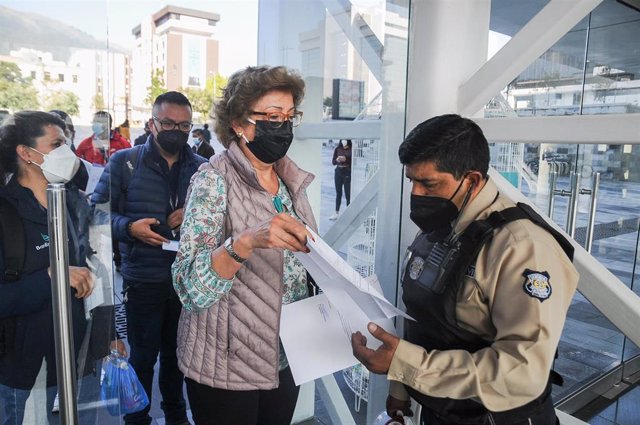 Archivo - Una mujer muestra su certificado de vacuncaión para entrar a un edificio en Ecuador en medio de la pandemia de coronavirus