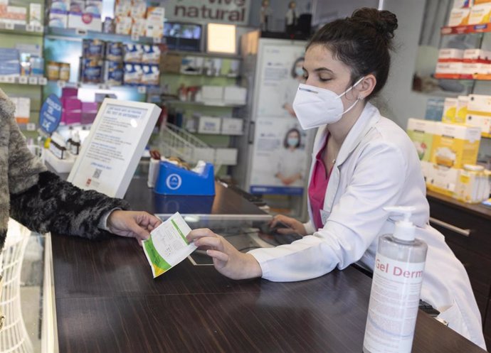 Una farmacéutica muestra un test de antígenos a una persona en la farmacia Las Gemelas, a 10 de enero de 2022, en Madrid (España). El presidente del Gobierno, ha anunciado que el Gobierno tiene previsto controlar los precios de los test de antígenos y